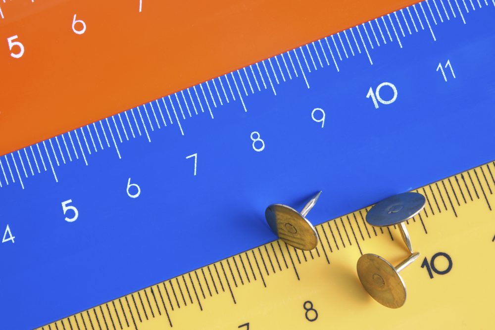 Orange, blue and yellow rulers with push pins